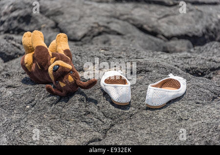 weiße Schuhe und Plüsch Hund auf Lavastein in Hawaii Big Island Stockfoto