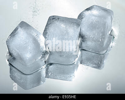 Drei Eiswürfel mit Reflektion auf grauem Farbverlauf Hintergrund. Stockfoto