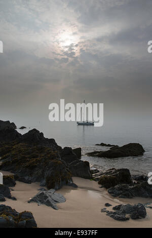 Segelboot vor Anker in der Morgendämmerung, Ynys Llanddwyn Island, Anglesey, North Wales, UK Stockfoto