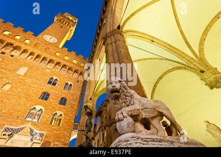 Europa, Italien, Florenz, Marmor Löwe Skulptur auf der Loggia dei Lanzi, mit dem Palazzo Vecchio im Hintergrund in der Abenddämmerung, Unes Stockfoto