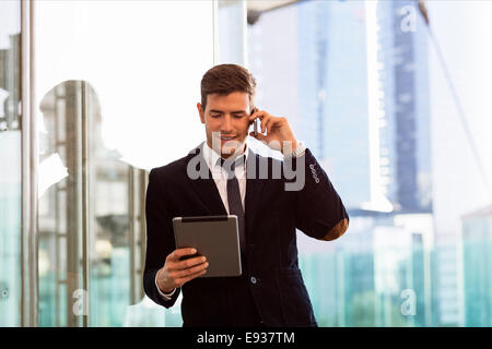 Geschäftsmann mit Handy und digitale Tablett Stockfoto