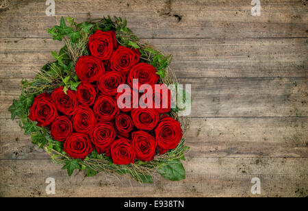 herzförmige rote Rosen auf rustikalen hölzernen Hintergrund. Valentinstag-Konzept. Retro-Stil getönten Bild Stockfoto