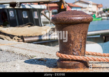 alt Poller mit Seil festmachen und Boote im Hintergrund Stockfoto