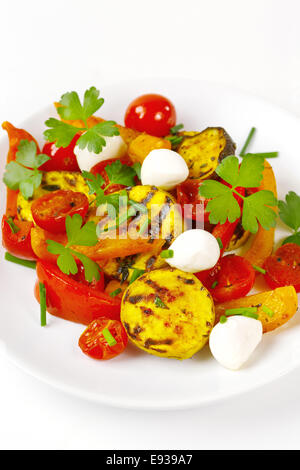 Gegrilltes Gemüse mit Mozzarella-Käse. Cherry-Tomaten, Paprika, Auberginen, Zucchini in weißem Teller auf weißem Hintergrund gedient Stockfoto
