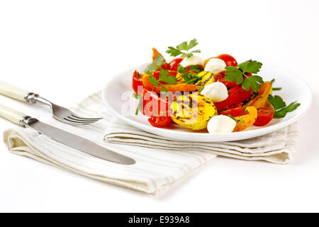 Gegrilltes Gemüse mit Mozzarella-Käse. Cherry-Tomaten, Paprika, Auberginen, Zucchini in weißem Teller auf weißem Hintergrund gedient Stockfoto