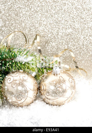 Goldene Weihnachtskugel mit Weihnachtsbaum Zweig im Schnee Stockfoto