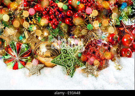 Weihnachtsbaum-Zweige mit Kugeln, goldenen Girlanden und Lichtern. Hintergrund mit bunten Bokeh Lichter Urlaub. Dunkeln konzipiert Stockfoto