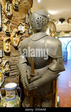 Mittelalterliche Ritter Rüstung in einem spanischen Tonwaren und Keramik Shop mit Karaffen auf dem Display in Mijas, Andalusien, Südspanien. Stockfoto