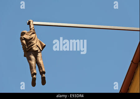 Eine Skulptur eines Mannes hängen von der Spitze eines Daches in der City von Prag, Tschechien. Stockfoto