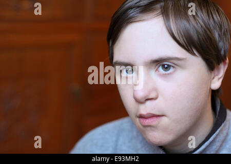 Junge mit Autismus, Down Syndrom, Innen- porträt Stockfoto
