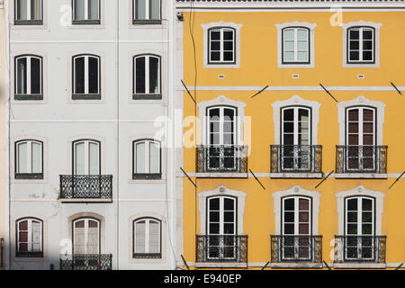 Traditionelle Reihenhäuser mit weißen und gelben Fassaden in Lissabon, Portugal. Stockfoto