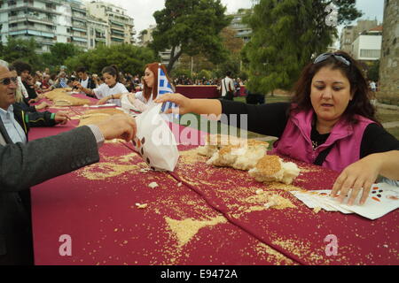 Thessaloniki, Griechenland. 19. Oktober 2014.  Die Leute bekommen kostenlose Brot am Ende der Veranstaltung. Bäcker aus Nordgriechenland errichtet eine 150 Meter lange "Koulouri" (eine traditionelle griechische Sesam-beschichtete Brot) in der zweitgrößten Stadt Thessaloniki, Griechenland.  Die Bäcker umgeben der Stadt ikonischen weißen Turm um einen Guinness-Rekord der weltweit längste Koulouri je gemacht Credit zu erreichen: Orhan Tsolak Alamy Live News Stockfoto