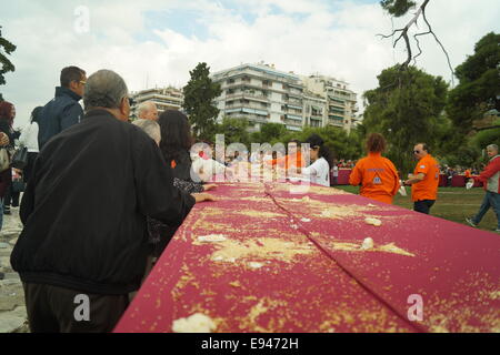 Thessaloniki, Griechenland. 19. Oktober 2014.  Menschen-Warteschlange, um Brot am Ende der Veranstaltung zu bekommen. Bäcker aus Nordgriechenland errichtet eine 150 Meter lange "Koulouri" (eine traditionelle griechische Sesam-beschichtete Brot) in der zweitgrößten Stadt Thessaloniki, Griechenland.  Die Bäcker umgeben der Stadt ikonischen weißen Turm um einen Guinness-Rekord der weltweit längste Koulouri je gemacht Credit zu erreichen: Orhan Tsolak Alamy Live News Stockfoto