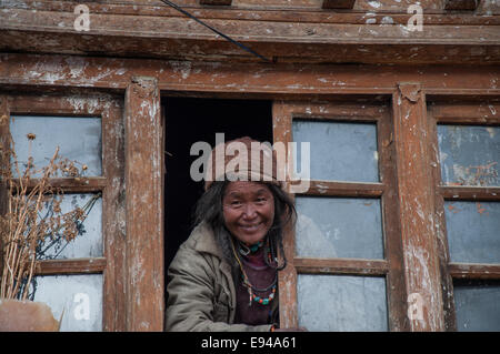 Dorf Dame ist Gruß Gäste aus Fenster in Zangla Dorf in der Region Ladakh von Bihar &. Stockfoto