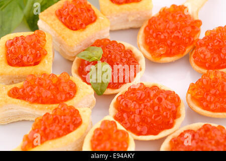 Roter Kaviar in Gebäck und Salat auf Teller. Stockfoto