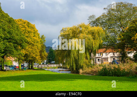 Fußgängerbrücke über den Fluß Leven Buck Inn in Herbstsonne auf dem Dorfanger Great Ayton North Yorkshire England Stockfoto