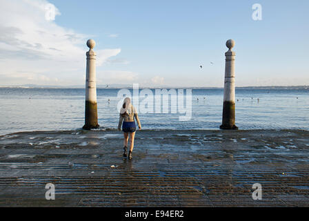 Junge Frau, die zu Fuß in der Praça Comércio am Abend, Commerce Square, Pombaline untere Stadt Baixa Pombalina, Lissabon, Portugal Stockfoto