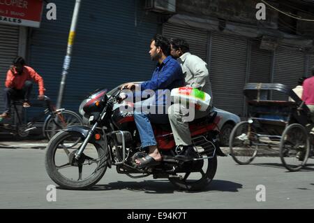 Zwei Männer auf einem Motorrad in den Seitenstraßen von Delhi Stockfoto