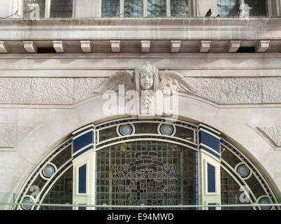 Dekorative Stein schnitzen eines geflügelten Cherub oberhalb eines inzwischen geschlossenen Tor Eingang in London Waterloo Station, geschäftigsten Bahnhof in Großbritannien Stockfoto