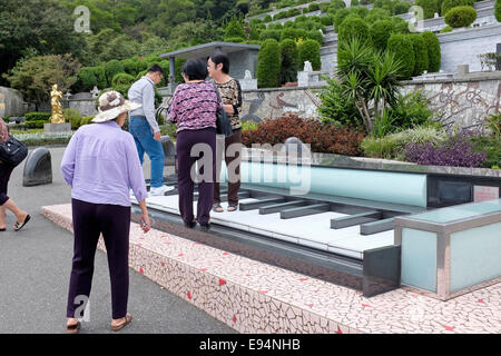 Touristen stehen auf einem Riesen Klavier am Grab des chinesischen Sängerin Teresa Teng in Jinshan, New Taipei City, Taiwan Stockfoto