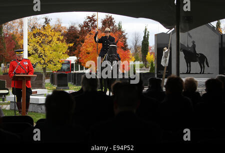 Ottawa, Kanada. 19. Oktober 2014. Ein Offizier der Royal Canadian Mounted Police sitzt auf ihrem Pferd als RCMP stellvertretender Kommissar Joe Oliver am Denkmal in der RCMP National Memorial Cemetery in Ottawa, Kanada, am 19. Oktober 2014 spricht. Der Friedhof, offen für ehemalige und aktuelle Mitglieder der RCMP, zivile Mitglieder, spezielle Polizisten und Mitglieder ihrer Familien wurde zum 10-jährigen Jubiläum des Friedhofs am Sonntag gefeiert. Bildnachweis: Cole Burston/Xinhua/Alamy Live-Nachrichten Stockfoto