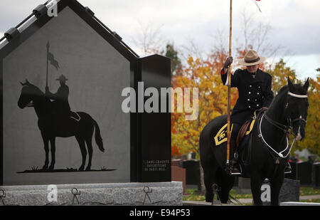 Ottawa, Kanada. 19. Oktober 2014. Ein Offizier der Royal Canadian Mounted Police sitzt auf ihrem Pferd neben einem Gedenkgottesdienst in der RCMP National Memorial Cemetery in Ottawa, Kanada, am 19. Oktober 2014. Der Friedhof, offen für ehemalige und aktuelle Mitglieder der RCMP, zivile Mitglieder, spezielle Polizisten und Mitglieder ihrer Familien wurde zum 10-jährigen Jubiläum des Friedhofs am Sonntag gefeiert. Bildnachweis: Cole Burston/Xinhua/Alamy Live-Nachrichten Stockfoto