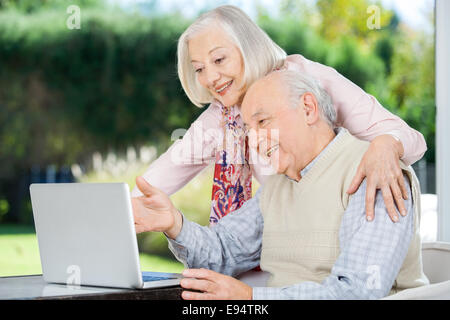 Fröhliche älteres Paar mit Laptop Stockfoto