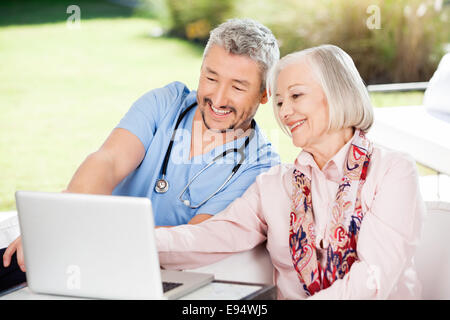 Hausmeister und ältere Frau mit Laptop Stockfoto