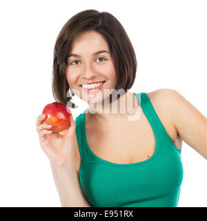 Schöne junge Brünette hält einen roten Apfel, isoliert auf weiss Stockfoto
