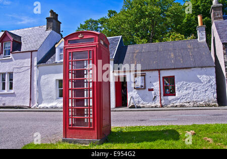 Rote Telefon Box auf Dorfstraße vor Zeile der alten traditionellen schottischen Cottages, Plockton, Highlands, Schottland, Vereinigtes Königreich Stockfoto