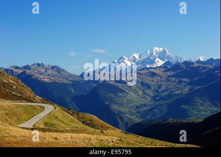 Die Passstrasse hinauf zum Col De La Madeleine, die schneebedeckten Gipfel des Mont Blanc Massivs auf der Rückseite, Alpen, Frankreich Stockfoto