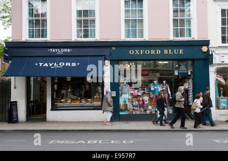 Menschen (Bewegung verwischt) zu Fuß vor Geschäften in Oxford High Street entfernt. Stockfoto