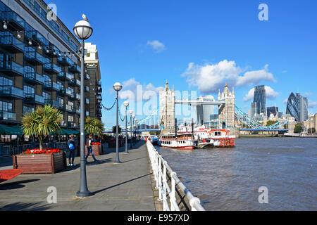 Butlers Wharf Fußweg am Flussufer mit Blick auf die Skyline der Tower Bridge und die modernen Hochhaus-Turmblöcke der City of London Flowers Planter Stockfoto