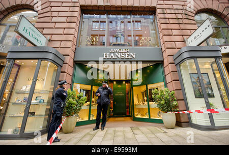 Hamburg, Deutschland. 20. Oktober 2014. Zwei Polizisten stehen vor einem Schmuck speichern nach einem Raubüberfall in Hamburg, Deutschland, 20. Oktober 2014. Am Montagmorgen beraubt zwei bewaffnete Männer den Store am Hamburger Jungfernstieg Promenade, Einnahme von Schmuck und Uhren. Foto: DANIEL BOCKWOLDT/Dpa/Alamy Live News Stockfoto