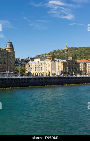 Rio Urumea in San Sebastian, im Hintergrund die Victoria Eugenia Theater und das Herz von Jesus Statue Stockfoto