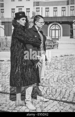 Junge Mode-paar posiert im Freien auf Schiene-Straße in kaltem, windigem Wetter, hübsche Mode Mann und Frau stehen auf Schienen in schwarz Stockfoto