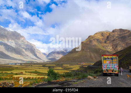 bunte LKW, Feldern und Bergen am Losar-Tal in Indien Stockfoto