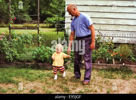 Großvater helfen Kleinkind Enkel zu Fuß Stockfoto