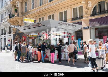 Menschen warten, um Würstchen in Wien zu kaufen. Es gibt viele Wurststand (Würstelstand) Verkauf von Hotdogs in der Stadt Stockfoto