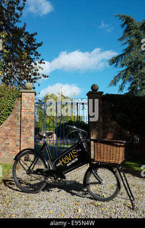 Jahrgang 1930 Bäcker (Kaufmann) Lieferung Fahrrad Weidenkorb mit alten Zeichen schreiben Hovis Werbetafel. Stockfoto