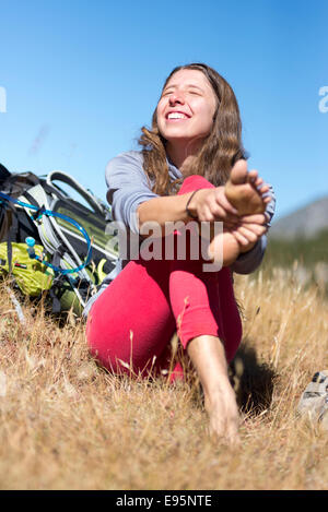 Frau, reiben ihre Füße auf einen Rucksack Reise in Oregon Wallowa Mountains. Stockfoto