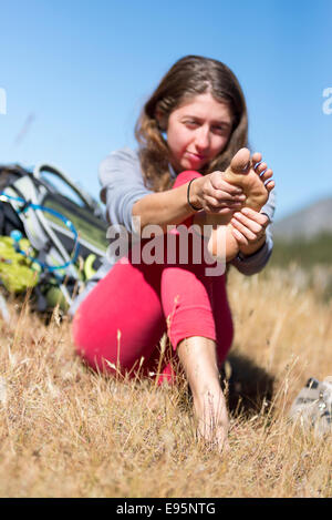 Frau, reiben ihre Füße auf einen Rucksack Reise in Oregon Wallowa Mountains. Stockfoto