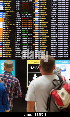 Personen an der Flugtafel Abflug, Terminal Nord, Gatwick Flughafen, Vereinigtes Königreich Stockfoto