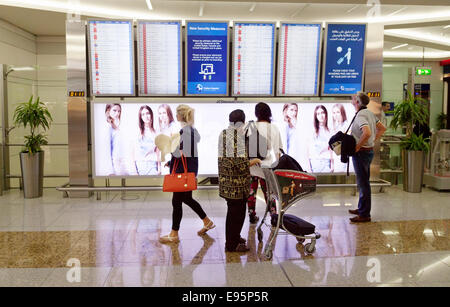 Fluggäste, die Blick auf die Abfahrtstafel, Flughafen Dubai, Vereinigte Arabische Emirate, Vereinigte Arabische Emirate Stockfoto