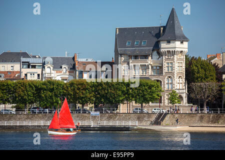 Im Sommer, ein kleines rotes Segelboot auf dem See Allier (Vichy). Petit voilier À Voiles Rouges Sur le Lac d ' Allier, À Vichy. Stockfoto