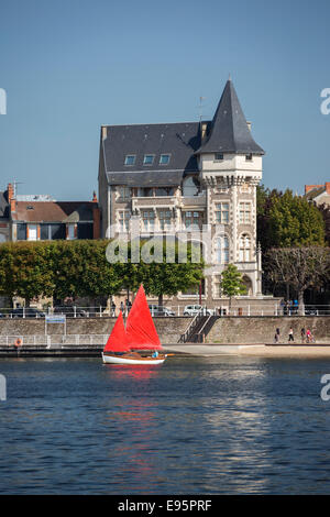 Im Sommer, ein kleines rotes Segelboot auf dem See Allier (Vichy). Petit voilier À Voiles Rouges Sur le Lac d ' Allier, À Vichy. Stockfoto