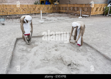 Mannequins der ursprünglichen Wari Bewohner bei der Arbeit die Lehmziegel im ikonischen Huaca Pucllana oder Huaca Juliana Pyramide, Miraflores, Lima, Peru Stockfoto