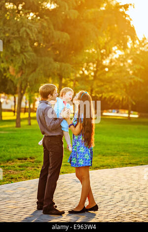 Glückliche Familie Mutter, Vater und Tochter gehen im Herbst Park. Tochter hält einen Lutscher Stockfoto