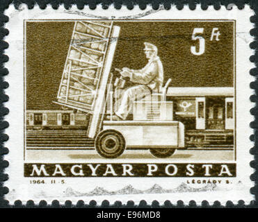 Ungarn - CIRCA 1964: Briefmarke gedruckt in Ungarn zeigt Hebebühne LKW und Post Auto, ca. 1964 Stockfoto