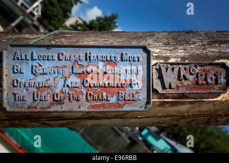 Nahaufnahme der zwei Metallplatten auf einem hölzernen Pfosten von den Docks in Bristol. Stockfoto